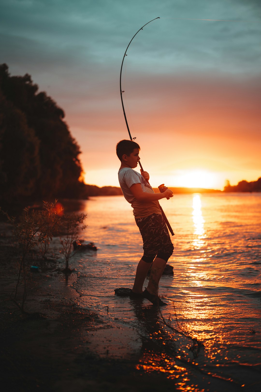 boy-in-white-shirt-and-brown-shorts-holding-fishing-rod-during-sunset-7-jriaa7p2a